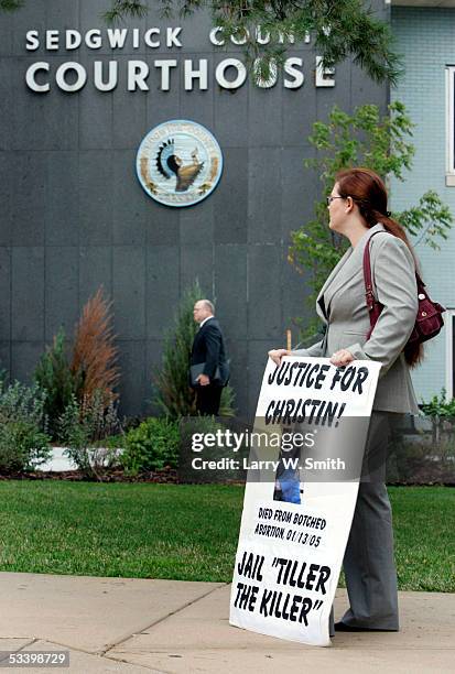 Brema Sullenger, a member of the pro-life group Operation Rescue, displays a placard referring to Dr. George Tiller outside the Sedgwick County...