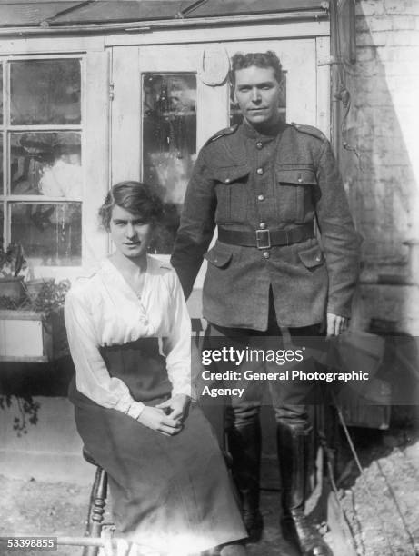 British soldier and his wife posing for a portrait in their back yard, circa 1915.