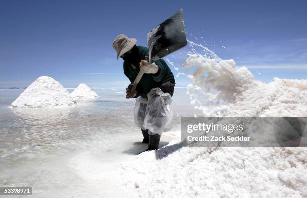 Salt miner who has worked for 22 years in the Salar de Uyuni shovels salt into a pile at the Salar de Uyuni January 27, 2005 in Bolivia. Bolivia's...