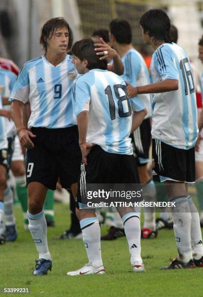 In his first match in the national team, Argentine Lionel Messi is comforted by his teammates Hernan Crespo and Luis Gonzales as he received a red...