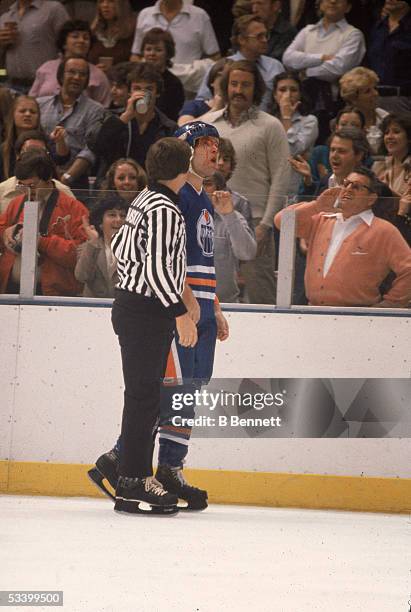 Fan in a cardigan sweater shouts at Canadian professional hockey player Dave Semenko of the Edmonton Oilers who has a bloody face after a fight with...