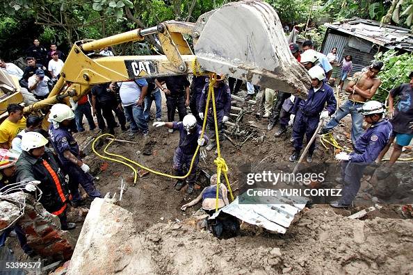 Dozer Rescuing Firemen and rescuers pull out from the rubble with a bulldozer the ...