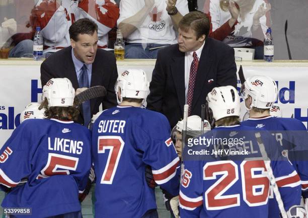 Team USA assistant coach David Quinn instructs his players as head coach Scott Sandelin looks on during the bronze medal game against Team Czech...