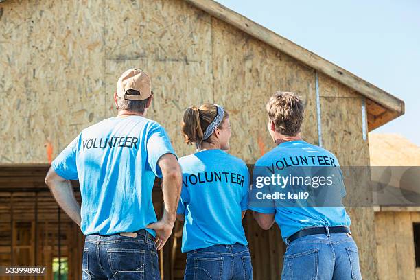 volunteers helping to build homes for the needy - giving back bildbanksfoton och bilder