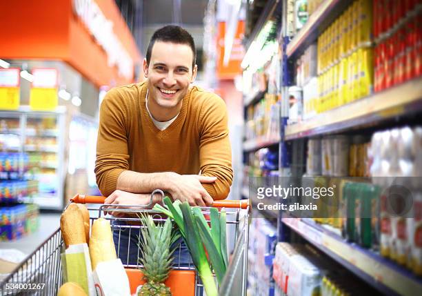 smiling handsome man in supermarket. - shopping cart stock pictures, royalty-free photos & images