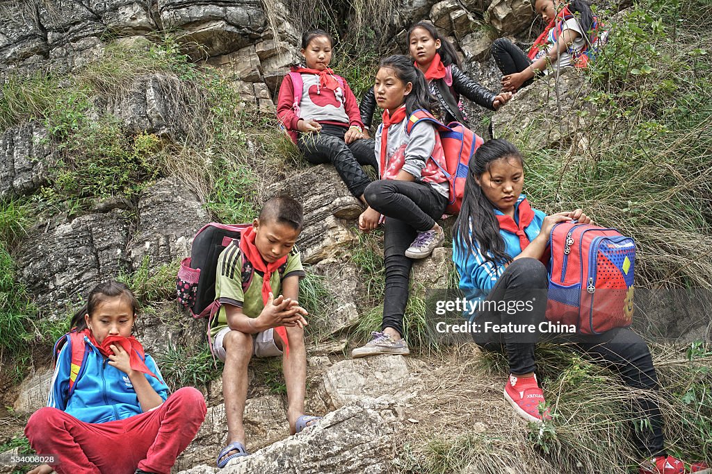 Children From Remote Chinese Village Climb Unsecured Vine Ladders On A Vertical Cliff