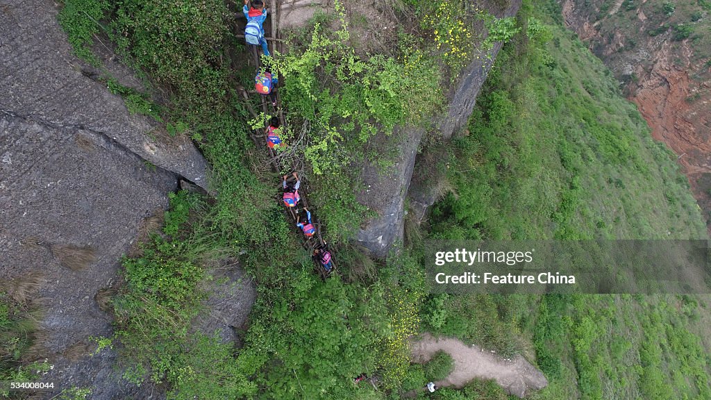 Children From Remote Chinese Village Climb Unsecured Vine Ladders On A Vertical Cliff