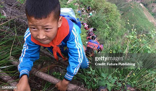 Children of Atule'er Village climb the vine ladder on a cliff on their way home in Zhaojue county in southwest China's Sichuan province on May 14,...