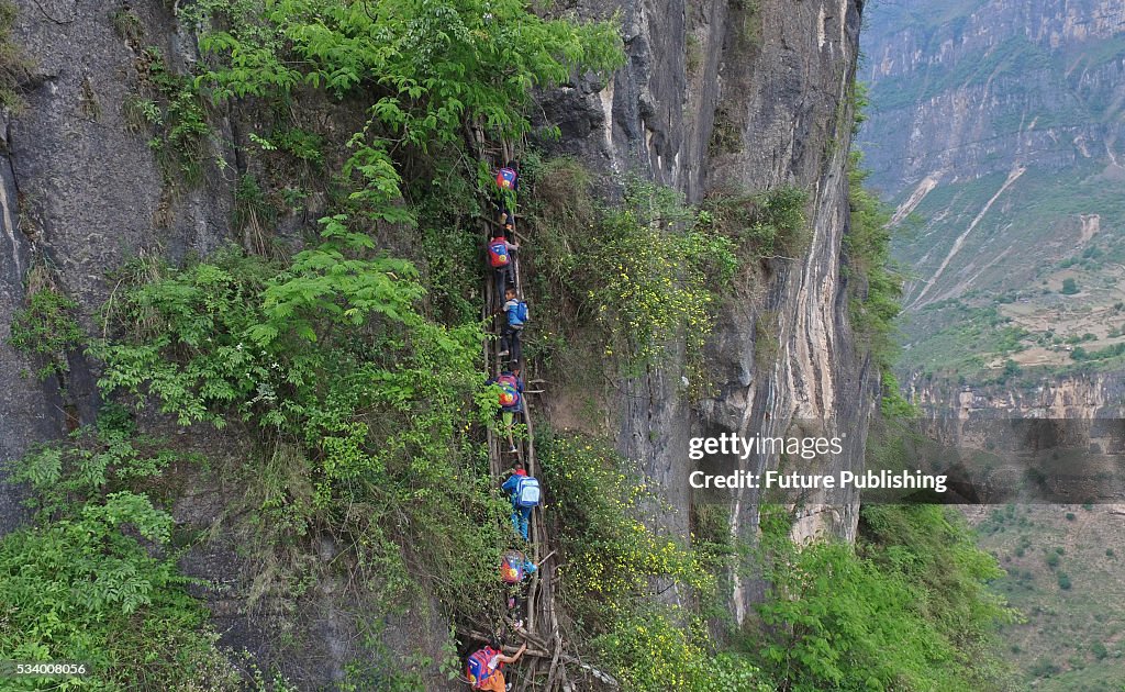 Children From Remote Chinese Village Climb Unsecured Vine Ladders On A Vertical Cliff