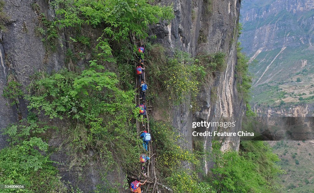 Children From Remote Chinese Village Climb Unsecured Vine Ladders On A Vertical Cliff