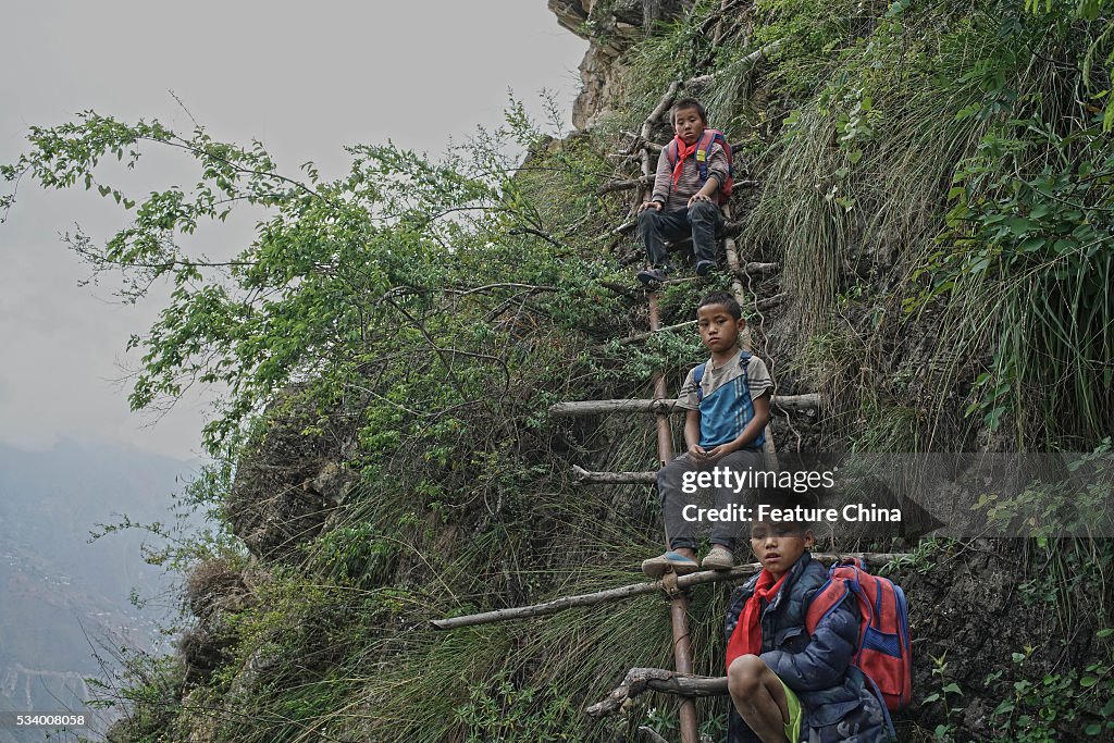 Children From Remote Chinese Village Climb Unsecured Vine Ladders On A Vertical Cliff