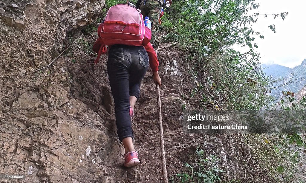 Children From Remote Chinese Village Climb Unsecured Vine Ladders On A Vertical Cliff