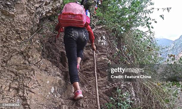 Children of Atule'er Village climb a cliff on their way home in Zhaojue county in southwest China's Sichuan province on May 14, 2016 in Zhaojue,...