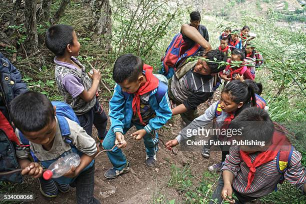 Children of Atule'er Village walk in a queue on their way home in Zhaojue county in southwest China's Sichuan province on May 14, 2016 in Zhaojue,...