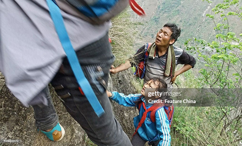 Children From Remote Chinese Village Climb Unsecured Vine Ladders On A Vertical Cliff