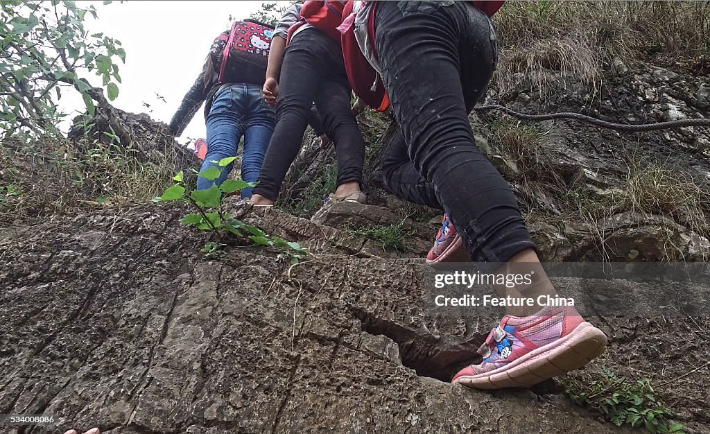 Children From Remote Chinese Village Climb Unsecured Vine Ladders On A Vertical Cliff