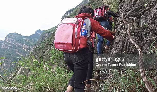 Children of Atule'er Village climb a cliff on their way home in Zhaojue county in southwest China's Sichuan province on May 14, 2016 in Zhaojue,...