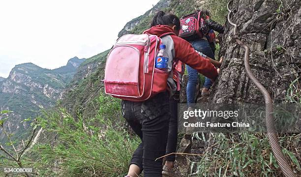 Children of Atule'er Village climb a cliff on their way home in Zhaojue county in southwest China's Sichuan province on May 14, 2016 in Zhaojue,...