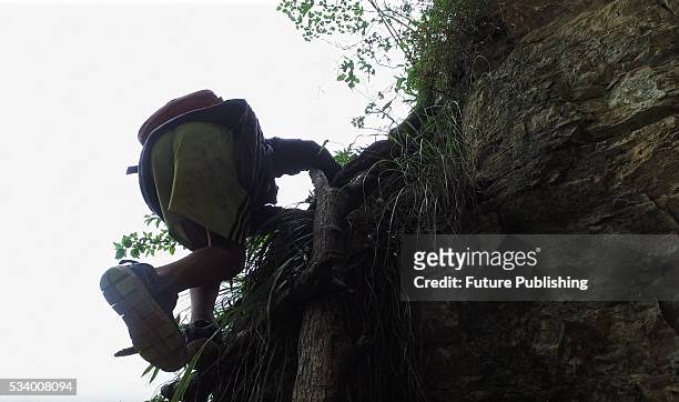 Child of Atule'er Village climbs a cliff on way home in Zhaojue county in southwest China's Sichuan province on May 14, 2016 in Zhaojue, China. There...