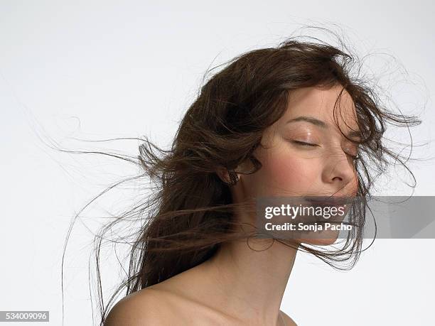 young woman with windswept hair - hair blowing stockfoto's en -beelden