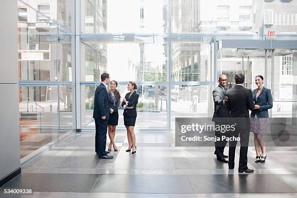 business people talking in lobby - lobby foto e immagini stock