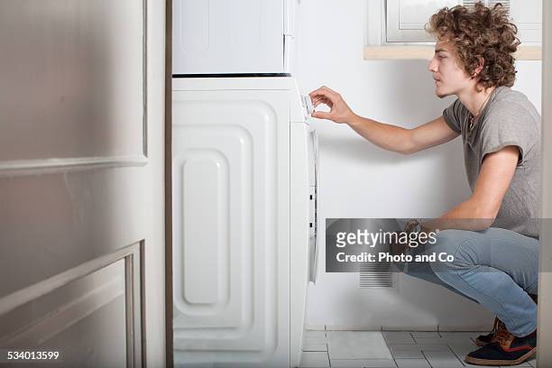 young man with the washing machine - washing curly hair stock pictures, royalty-free photos & images