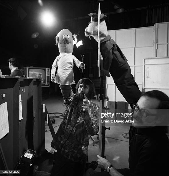 Puppeteers Jim Henson holding an 'Anything Muppet' dentist and frank Oz with an 'Anything Muppet' postman rehearse for an episode of Sesame Street at...