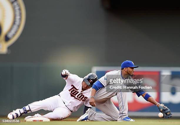 Oswaldo Arcia of the Minnesota Twins slides into second base safely to second base with a double as the throw passes Alcides Escobar of the Kansas...
