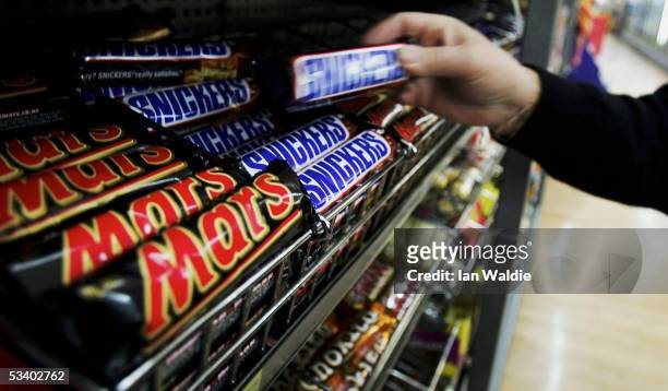 Customer picks up a Snickers Bar in a supermarket August 18, 2005 in Sydney, Australia. Mars and Snickers bars returned to NSW shops today after...