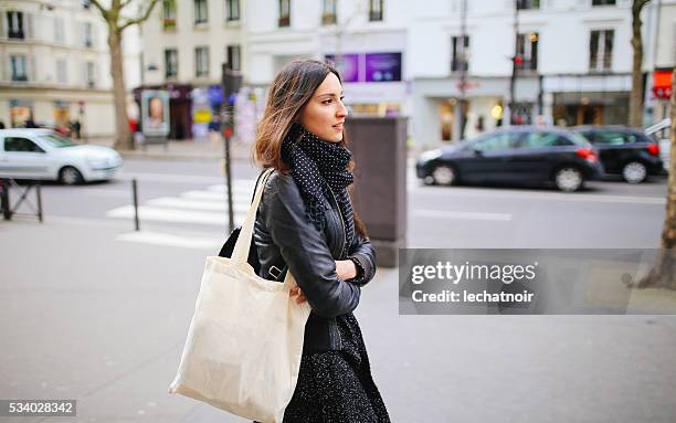 junge frau zu fuß in paris - henkeltasche stock-fotos und bilder