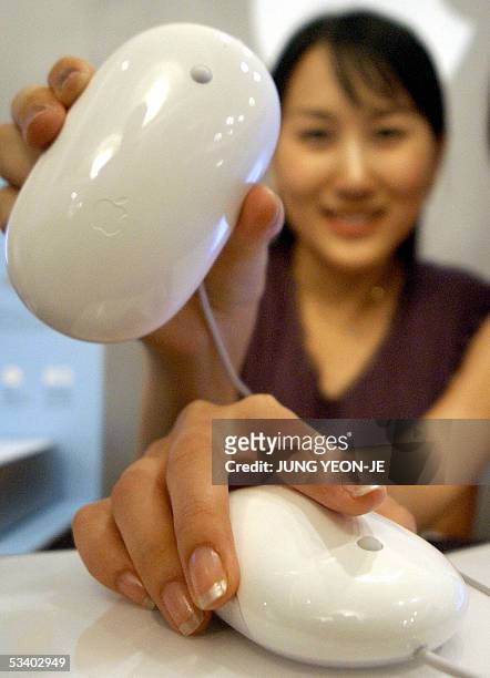 Woman shows new Apple Computer mouses during its sales promotion in Seoul, 18 August 2005. Apple Computer Korea began selling the new "Mighty Mouse"...