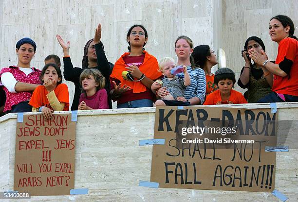 Militant Jewish settlers barricade themselves on the balcony of their synagogue as hundreds of Israeli troops and police deploy at sunrise on August...