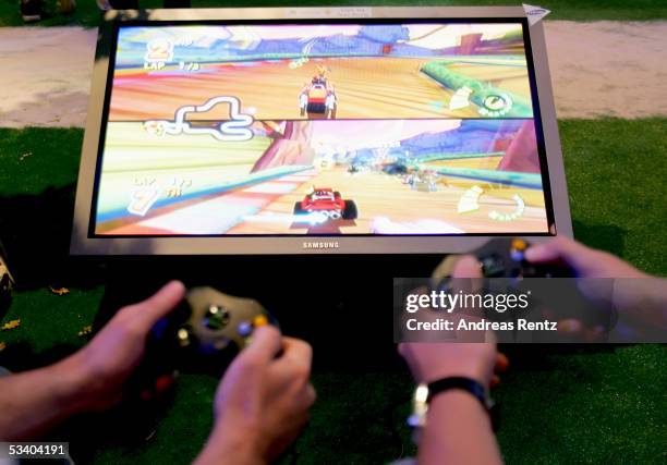 Visitors play at the Microsoft "XBOX 360" stand at a Computer Gaming Convention on August 18, 2005 in Leipzig, Germany. The convention is Germany's...