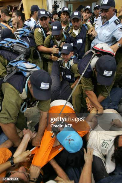 Israeli settlers are evacuated from the synagogue of the southern Gaza Strip settlement of Neve Dekalim 18 August 2005. Israeli police dragged dozens...