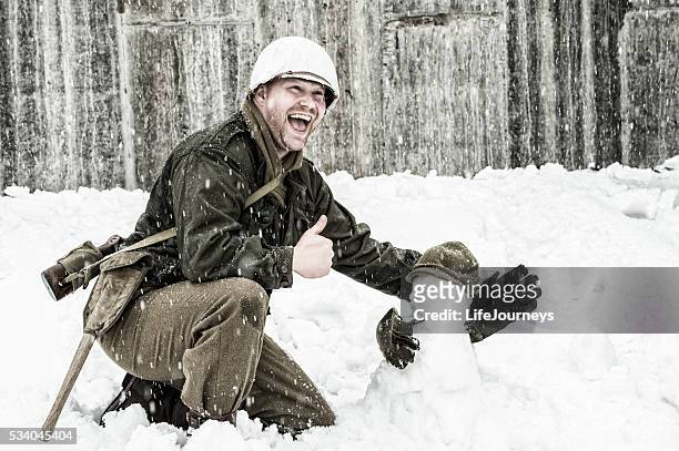 wwii us infantry man building a snowman and laughing - 1944 stock pictures, royalty-free photos & images