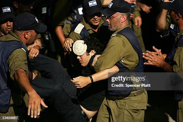 Settler protester is taken away by military police from the synagogue after it was raided August 18, 2005 the Israeli settlement of Neve Dekalim in...