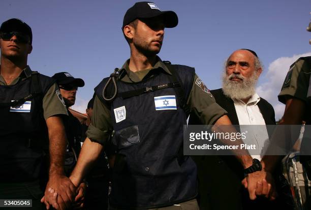 Settler peers out over military police officers August 18, 2005 the Israeli settlement of Neve Dekalim in the Gush Katif block of Settlements in...