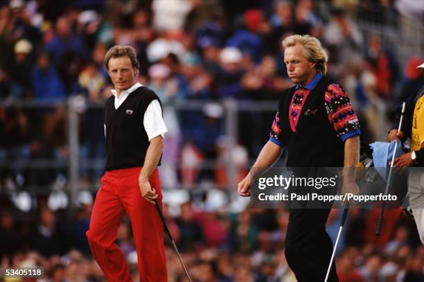 German professional golfer Bernhard Langer and Greg Norman of Australia walk down the fairway during play in the final round of the 1993 Open...