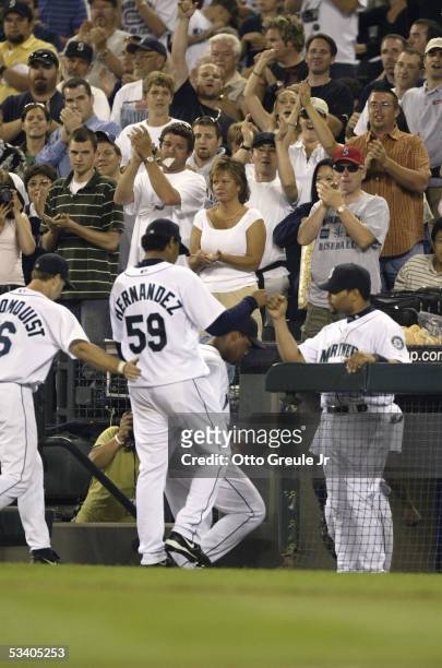 Starting Pitcher Felix Hernandez of the Seattle Mariners is congratulated by teammates he walks to the dugout during the game against the Minnesota...