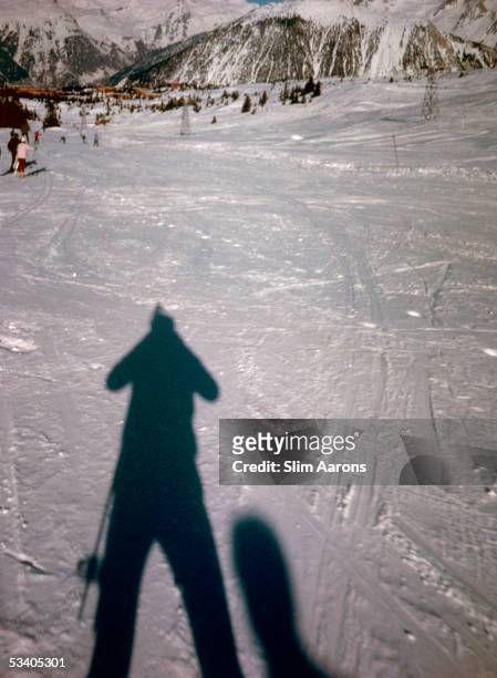 American photographer Slim Aarons takes a picture of his own shadow on the ski slopes at Courcheval, France, 1963.