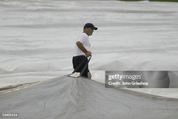 Member of the grounds crew of the Cleveland Indians handles the tarp during the game against the Chicago White Sox at Jacobs Field on July 16, 2005...