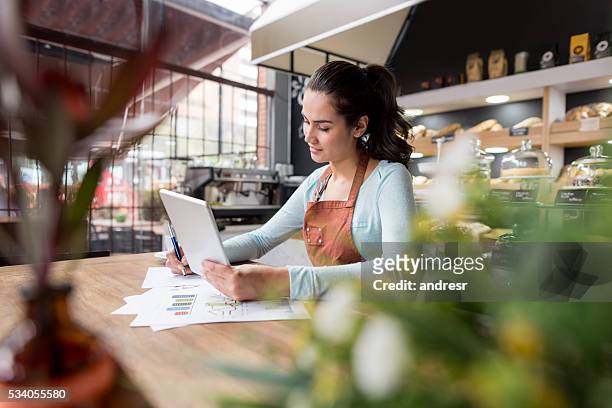 woman doing the books at a restaurant - entrepreneur stock pictures, royalty-free photos & images