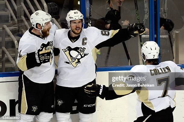 Sidney Crosby of the Pittsburgh Penguins celebrates with his teammates Phil Kessel and Matt Cullen after scoring a goal against Andrei Vasilevskiy of...