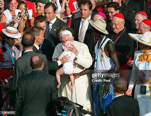 German-born Pope Benedict XVI takes a child in his arms on August 18, 2005 as he visits the city of Cologne, Germany. The Pope is paying a four-day...