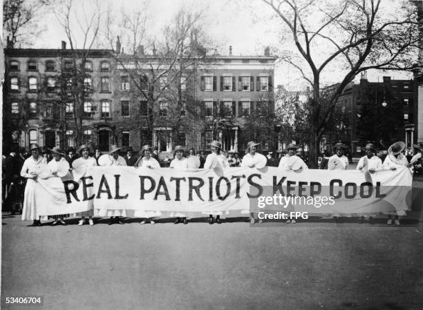 View of women from the Woman's Peace Party as they stand and hold a banner which reads 'Real Patriots Keep Cool' to demonstate against US involvment...