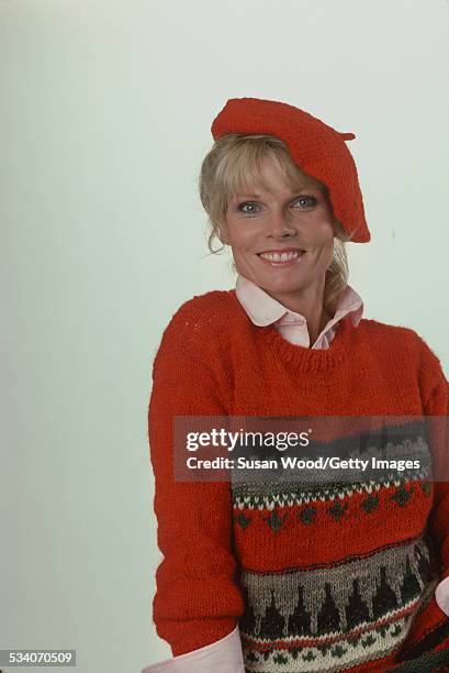 Portrait of American actress and television personality Cathy Lee Crosby as she poses in a red sweater and a beret, July 1980.