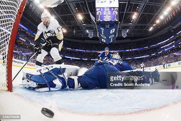 Goalie Andrei Vasilevskiy of the Tampa Bay Lightning stretches but misses the save against Bryan Rust of the Pittsburgh Penguins and lets in a goal...