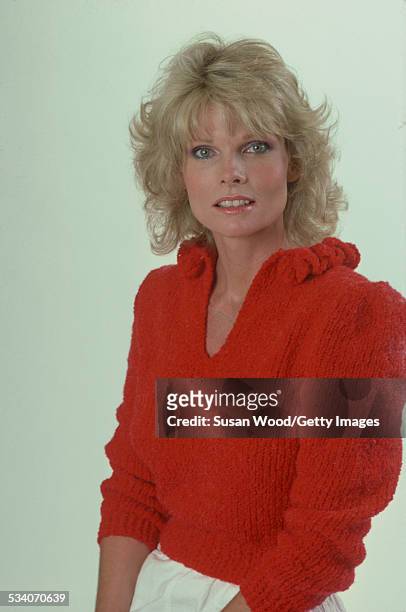Portrait of American actress and television personality Cathy Lee Crosby as she poses in a red sweater and white trousers, July 1980.