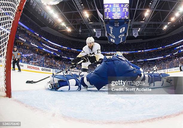 Goalie Andrei Vasilevskiy of the Tampa Bay Lightning stretches but misses the save against Bryan Rust of the Pittsburgh Penguins and lets in a goal...