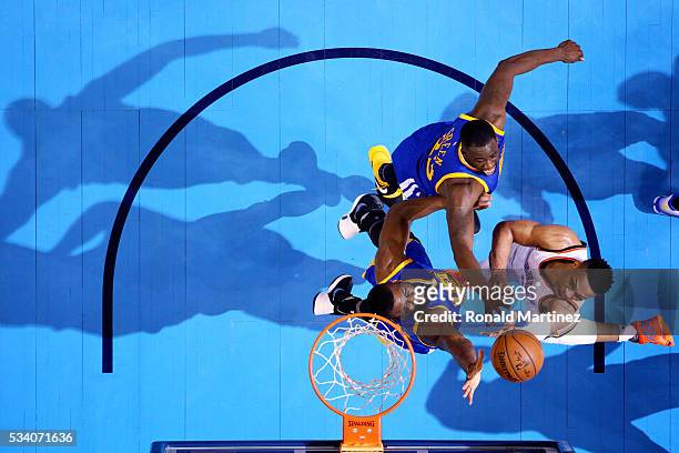 Russell Westbrook of the Oklahoma City Thunder shoots against Draymond Green and Festus Ezeli of the Golden State Warriors in the first half in game...